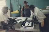 Artist: Tremblay, Theo. | Title: Andrew Margalulu (left) and Philip Gudthay Kudthay, painting on stone at the Theo Trenblay print workshop, Ramingining, April 1997. | Date: April 1997