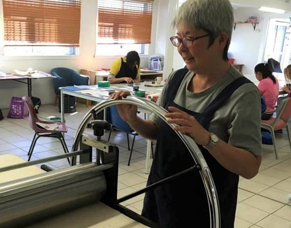 Title: b'Kay Watanabe, Australian printmaker, at the etching press, Brisbane, 2019.'