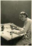 Title: b'Una Foster at her drafting table, early 1950s?'